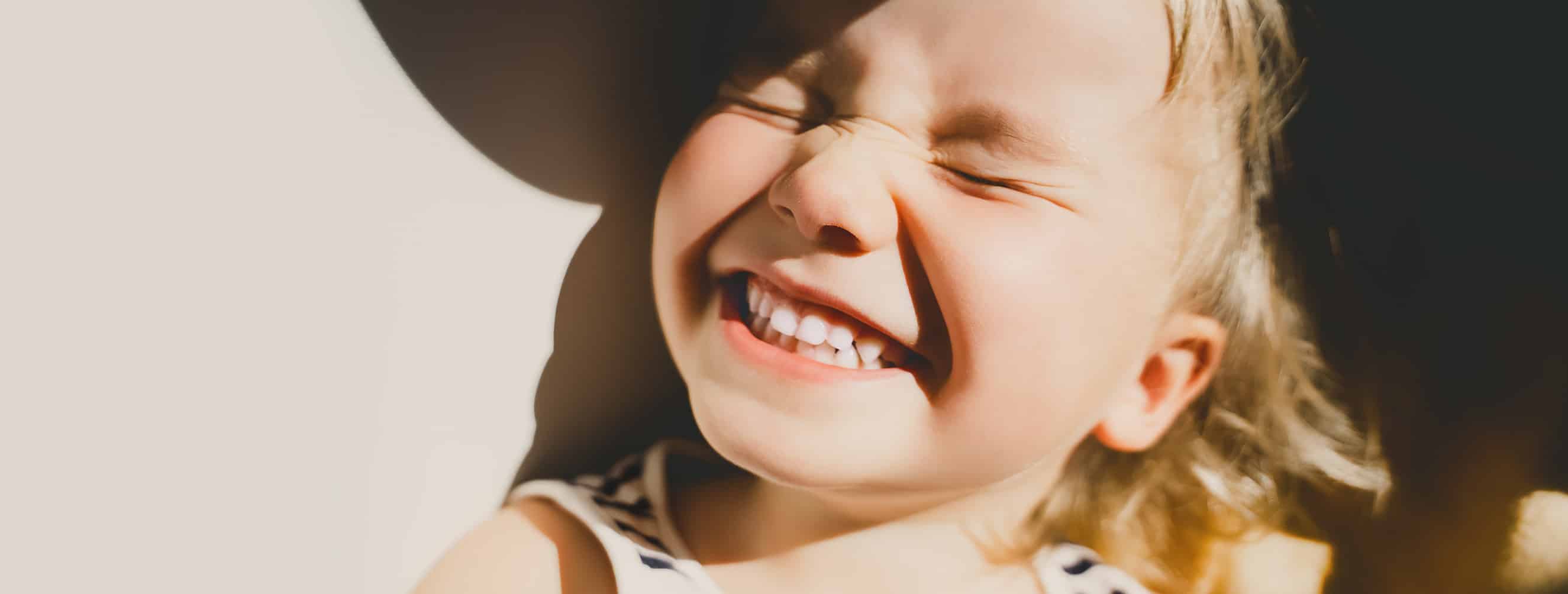 Happy child smiling in the sun after leaving the dentist.